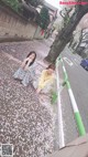 A couple of women sitting on the side of a road.