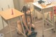 A woman sitting on the floor in front of a desk.