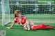 A woman laying on the ground with a soccer ball.