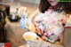 A woman pouring tea into a cup in a kitchen.