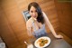 A woman sitting at a table with a plate of food.