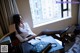 A woman sitting at a desk in front of a window.