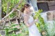 A woman in a white dress holding an ice cream cone.