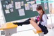 A woman sitting on a chair in front of a blackboard.